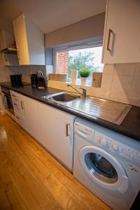 a kitchen with a sink and a washing machine at George St Apartment that sleeps up to 4 in Salisbury