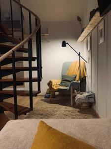 ein Wohnzimmer mit einem Stuhl und einer Treppe in der Unterkunft Fügéskert in Balatongyörök