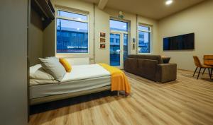 a bedroom with a bed and a couch and a chair at Center apartments - Hekla in Reykjavík