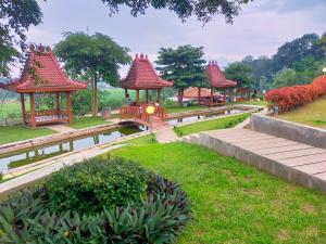 un grupo de cenadores en un parque con un puente en Joglo Kumpul Resort, en Cangkiran