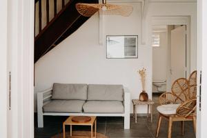 a living room with a couch and chairs at Nid Kréyol Domaine de Charme avec Villas, Piscine Privée & Jacuzzi in Sainte-Anne