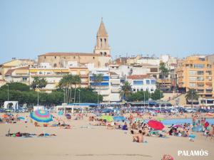 uma multidão de pessoas numa praia com edifícios em Espectacular apartament a Palamós centre! Amb WIFI em Palamós