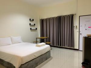 sypialnia z dużym łóżkiem i oknem w obiekcie Ban Bunsawaeng Resort w mieście Chaiyaphum