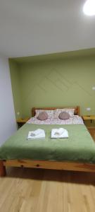 a bedroom with a bed with two towels on it at KovacInalux Apartmani in Pale