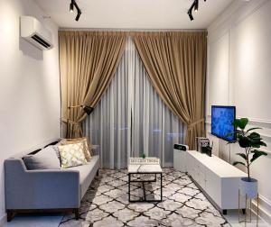 a living room with a couch and a tv at SKY COZY TROIKA RESIDENCE, 1 BEDROOM 4-6 PAX, 2 BEDROOMS 6-8 PAX, POOL VEW, SKY & CITY VIEW, Free Parking, Pool, Unlimited Wifi in Kota Bharu