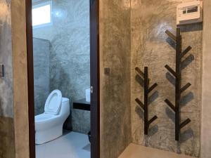 Łazienka z toaletą i prysznicem ze szklanymi drzwiami w obiekcie Ban Bunsawaeng Resort w mieście Chaiyaphum