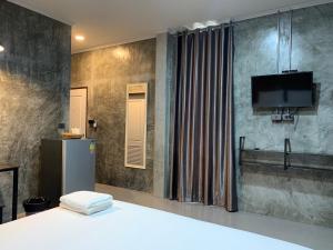 sypialnia z łóżkiem i telewizorem na ścianie w obiekcie Ban Bunsawaeng Resort w mieście Chaiyaphum