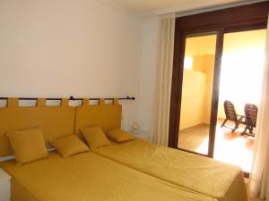 貝納爾馬德納的住宿－Penthouse Benalvistas Torregolf Seaview，一间卧室配有一张带黄色床单的大床