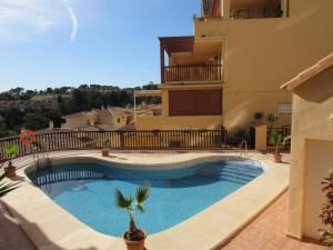 a swimming pool in front of a house at Penthouse Benalvistas Torregolf Seaview in Benalmádena