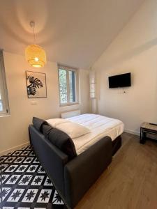 a bedroom with a bed and a couch in it at LOFT DU BRAS DOR in Boulogne-sur-Mer
