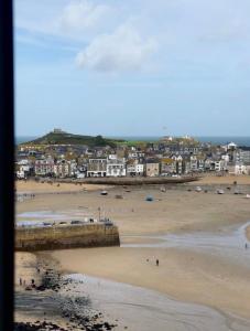 a view of a beach with a town in the background at Harbour View House in St Ives