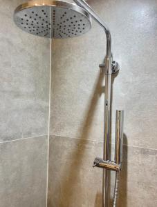 a shower with a shower head in a bathroom at Harbour View House in St Ives