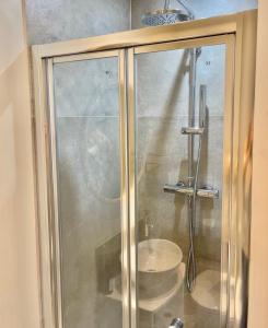 a glass shower with a sink in a bathroom at Harbour View House in St Ives
