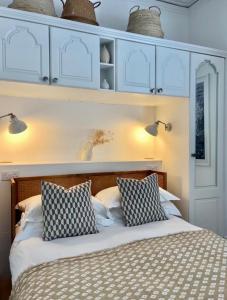 a bedroom with a bed with blue cabinets and pillows at Harbour View House in St Ives