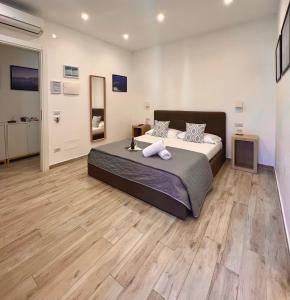 1 dormitorio con 1 cama grande y suelo de madera en Effe Home Sorrento, en Sorrento