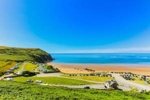 an aerial view of a beach with cars parked at Croyde Ocean Breeze 5 Bedrooms in Croyde