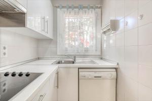 a white kitchen with a sink and a window at Isla Cartago 49 Empuriabrava - Immo Barneda in Empuriabrava