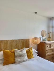a bedroom with a white bed with yellow pillows at Harbour View House in St Ives