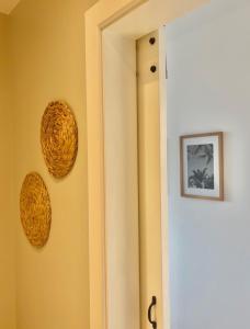 a hallway with a door and two baskets on the wall at Harbour View House in St Ives