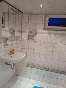 a white bathroom with a sink and a window at Kleine Unterkunft für Selbstversorger in Nuremberg