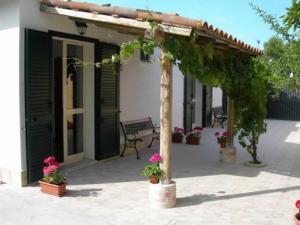 a pergola with flowers and a bench in a courtyard at Villa Verdemare Naxos in Giardini Naxos
