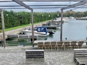 a dock with chairs and a boat on the water at OccO in Willebroek