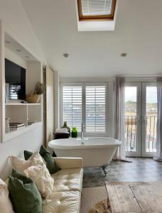 a large white tub in a living room with a couch at Harbour View House in St Ives