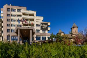 un edificio de hotel con una torre de reloj en el fondo en Faleza Hotel by Vega en Galaţi