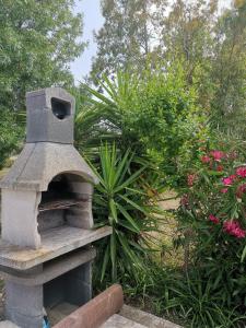 a stone oven in a garden with some plants at Patio House in Siniscola