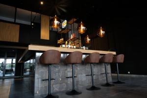 un bar con cinco taburetes marrones en un mostrador en OccO, en Willebroek