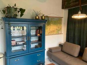 a blue cabinet in a living room with a couch at Appartement de Tuinkamer in Kampen