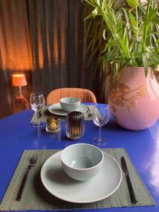 a blue table with plates and bowls and a vase at Appartement de Tuinkamer in Kampen