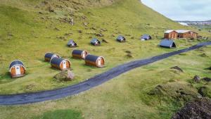 Eine Gruppe kleiner Häuser auf einem Hügel in der Unterkunft Glamping & Camping in Vestmannaeyjar