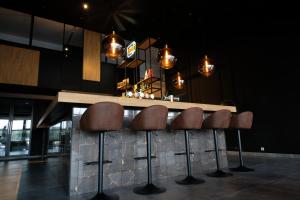 um bar com cinco bancos castanhos num balcão em OccO em Willebroek