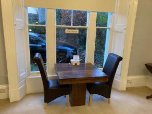 a table with two chairs and a car in a window at The Corner House Bed & Breakfast in Whitehaven