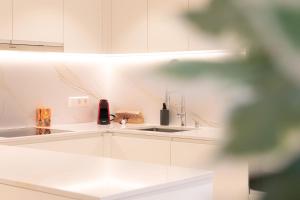 uma cozinha com armários brancos e um lavatório em Hamilius Apartments City Center Luxembourg by Rentaroo em Luxemburgo