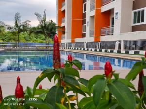 vista para a piscina num resort com flores vermelhas em Pavilionvillie M1T570 by irainbow em Ipoh