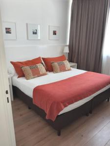 1 dormitorio con 1 cama grande con manta roja en Rental Suites Pilar en Pilar