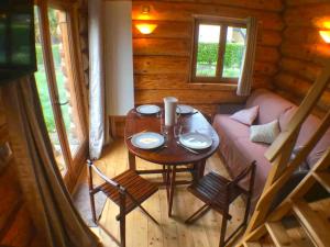 una habitación con una mesa y un sofá en una cabaña en L'ermitage des vallons, en Sulniac