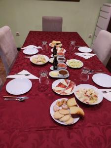 una mesa roja con platos de comida. en Alvares de Corvera, en El Pontón