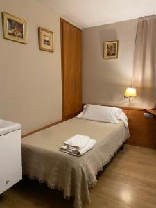 a bedroom with a bed with two towels on it at HOSTAL GALICIA CARDEDEU in Cardedeu