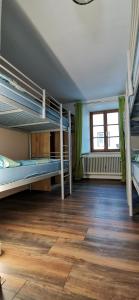 a room with two bunk beds and a wooden floor at Gasthof Hirschen in Pfunds