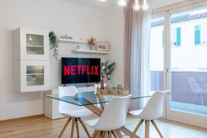 een eetkamer met een glazen tafel en witte stoelen bij Art Design Home Firenze in Florence +12 foto's