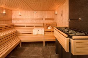 a sauna with a tub and a stove in it at Charming Hazel Lodge - Relaxing Devon Getaway in Chudleigh