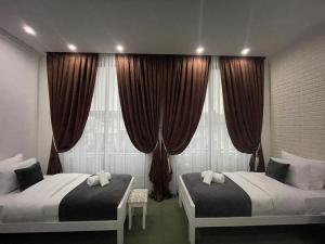 - une chambre avec 2 lits et une fenêtre avec des rideaux dans l'établissement Hotel PALACE, à Velika Kladuša