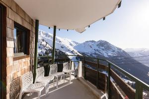 a balcony with chairs and a view of mountains at Spacious Stylish apartment for 8 by Avoriaz Chalets in Avoriaz