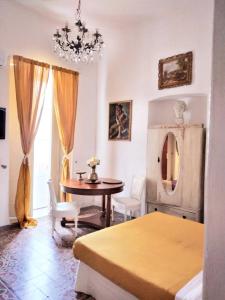 a bedroom with a table and a dining room at B&b Morosoli Palace in Catania