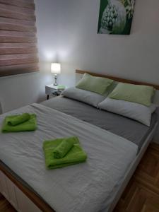 uma cama com toalhas verdes em cima em Stan na dan MB Istocno Sarajevo em Lukavica