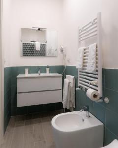 uma casa de banho com um lavatório branco e um espelho. em Dimora Cavour em Nápoles