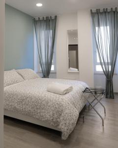 um quarto com uma cama com um cobertor e um espelho em Dimora Cavour em Nápoles